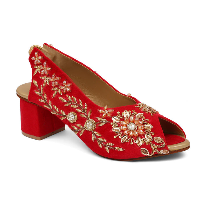 A pair of red open-toe platform wedges with ivory velvet material and gold embroidery, featuring a removable ankle strap.