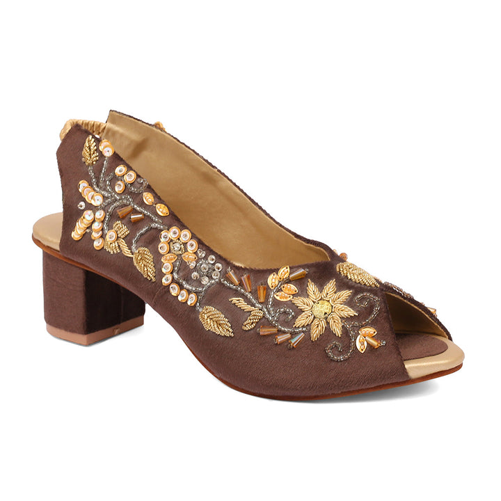 A pair of brown open-toe platform wedges with embroidered details on a bridal collection.