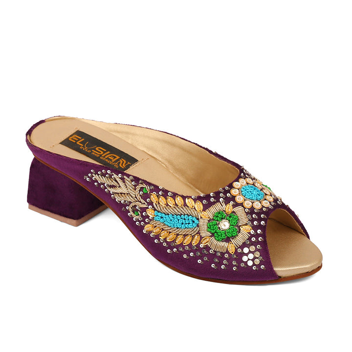A pair of purple velvet open-toe platform wedges with embroidery and a removable ankle strap.