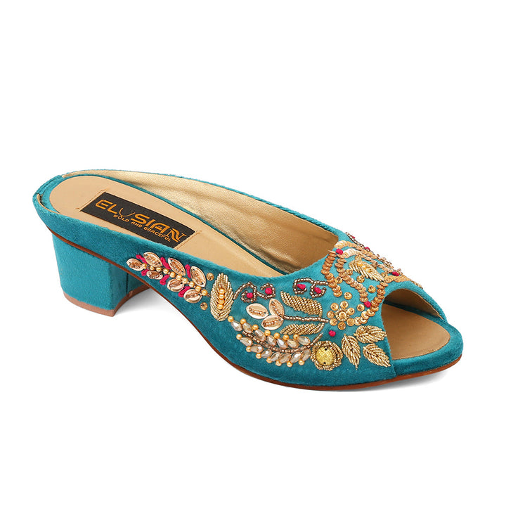 A blue velvet open-toe platform wedge with intricate embroidery and a dainty ankle strap.