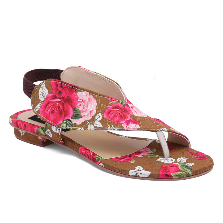 A pair of brown sandals with a floral pattern, featuring pink and green flowers, and a brown strap.