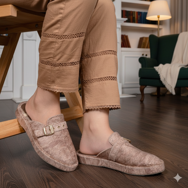 Person wearing brown slippers on a wooden floor with a blurred background