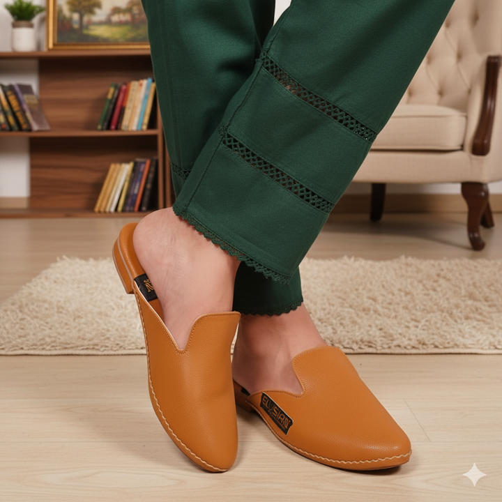 Person wearing green pants and brown slippers in a home setting