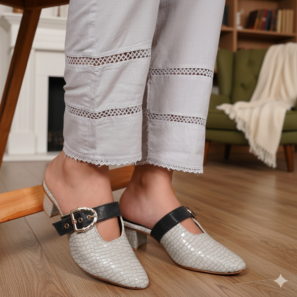 White woven shoes with black straps worn by a person in a home setting.
